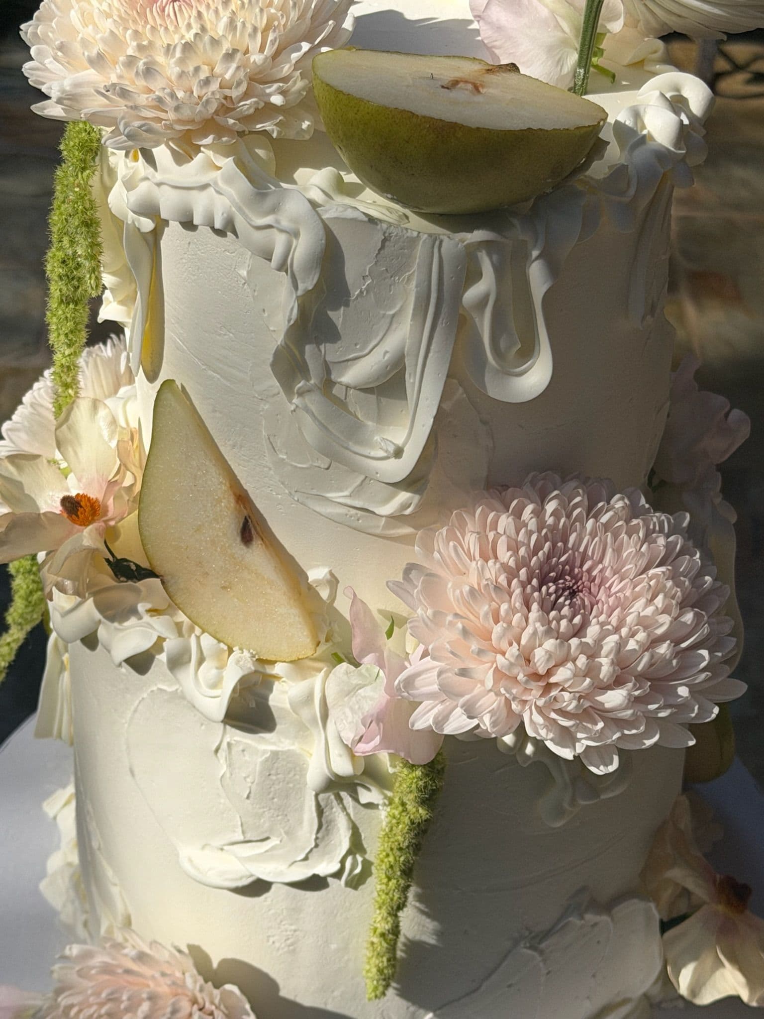 Detail of sculpted buttercream drapes with pear slices, blush chrysanthemum and sweet pea