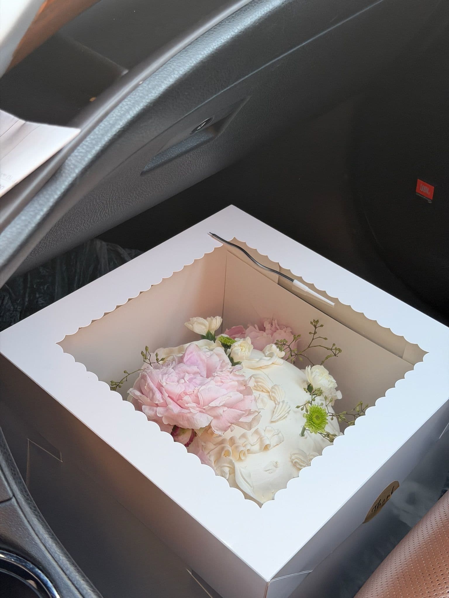 Cake finished with a full blush peony, spray carnations and green chrysanthemum, boxed for delivery